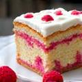 Slice of classic vanilla bean cake with fresh raspberries