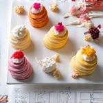 Hand-drawn cake design sketches next to a plate of gourmet cake samples